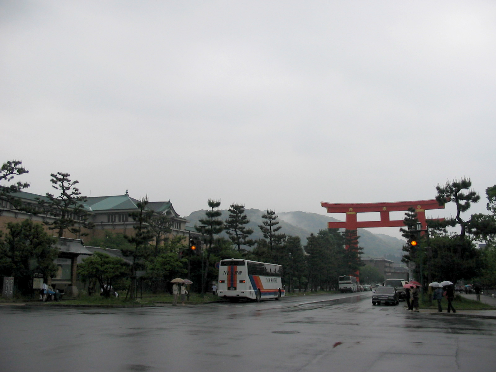 large orange torri gate with tour bus in foreground