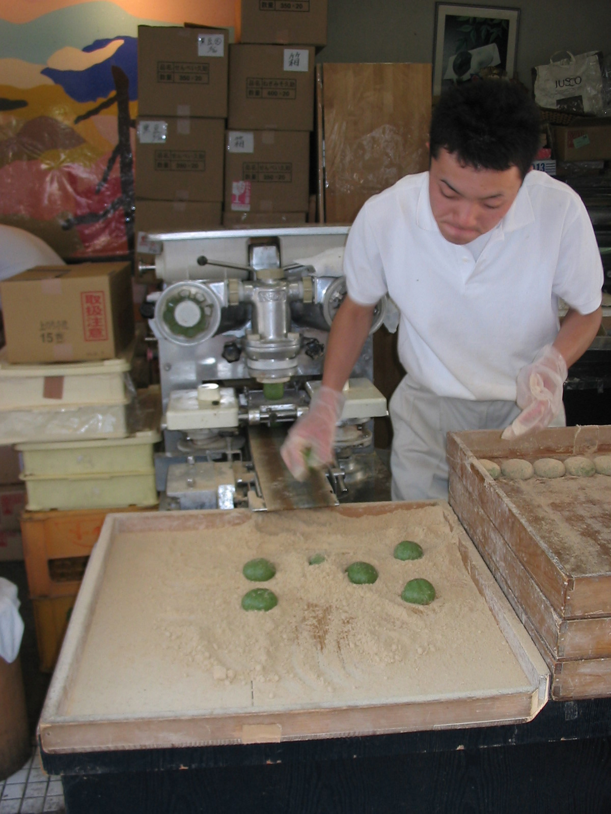 man dipping mochi into crumbs