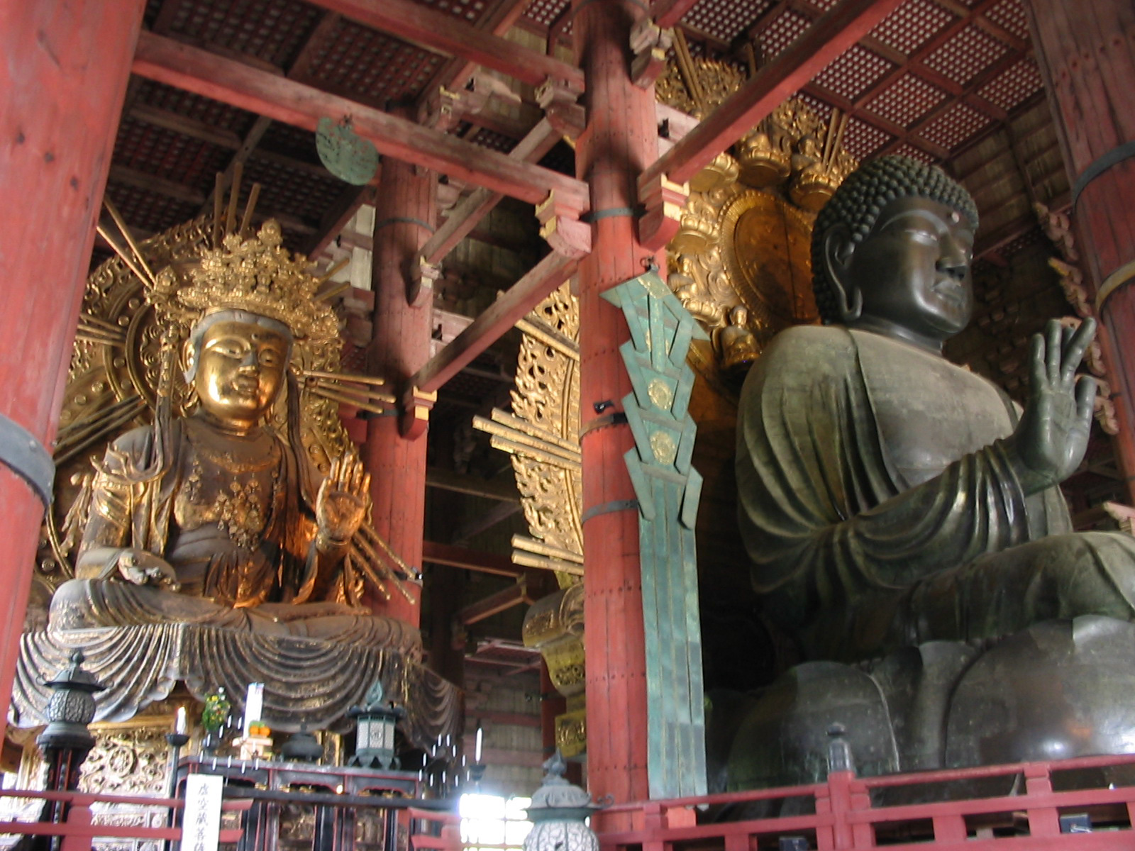 large bronze buddha next to smaller gold buddha