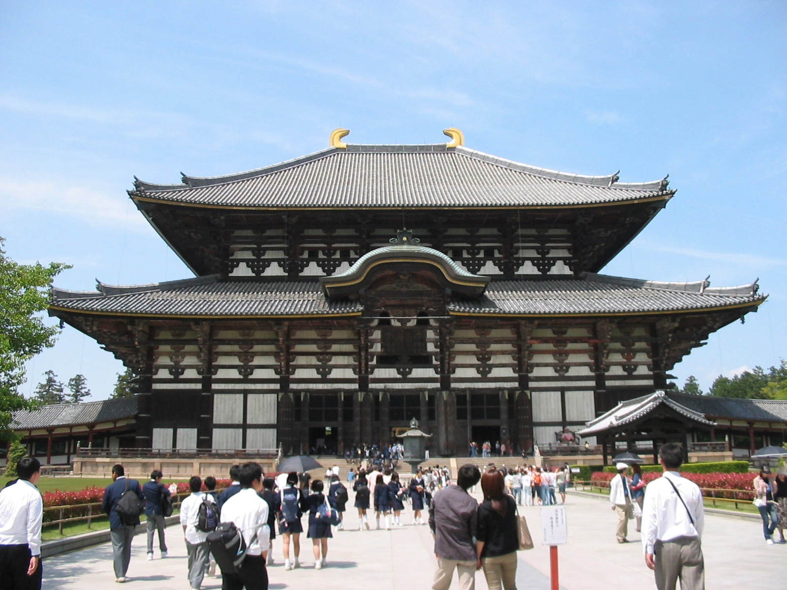 two-storey wooden building with tourists walking around in front