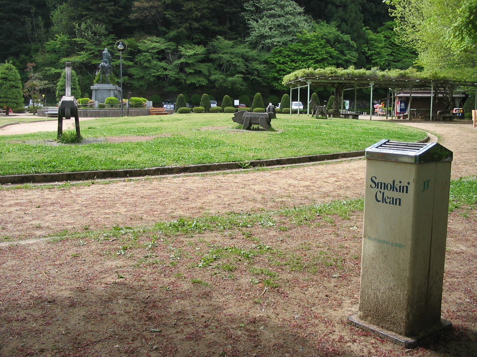 playground with wooden statues and an outdoor ashtray with the words smokin' clean