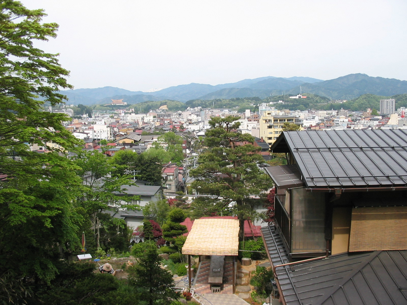 view of takayama from shiroyama park with houses in the foreground and temple and mountains in the background