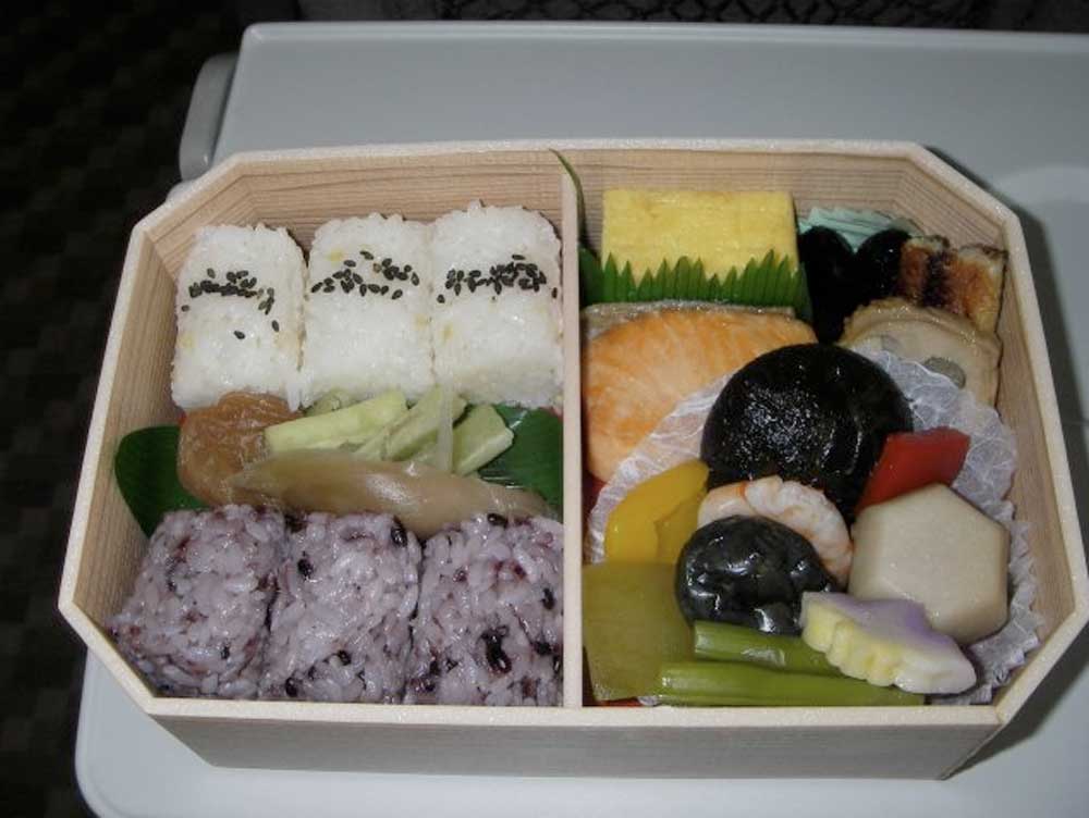 bento box with rice, fish, and beans